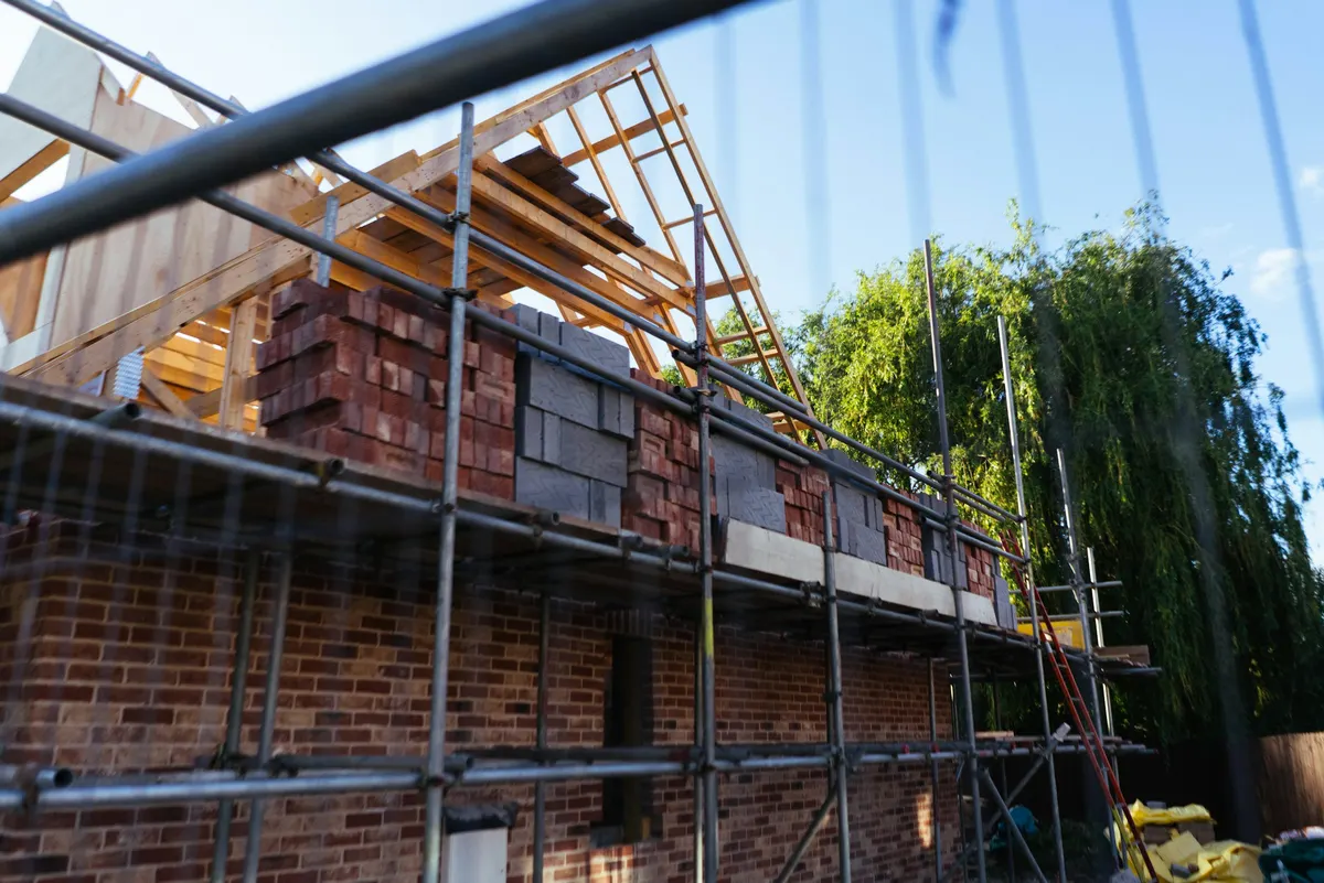 Symbolbild: Klinkerhaus im Bau mit Gerüst und Dachstuhl